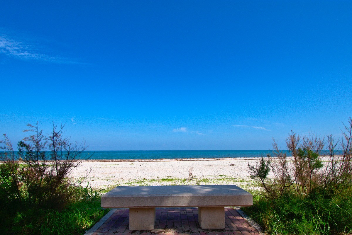 asiento en playa de piedras y mar de fondo